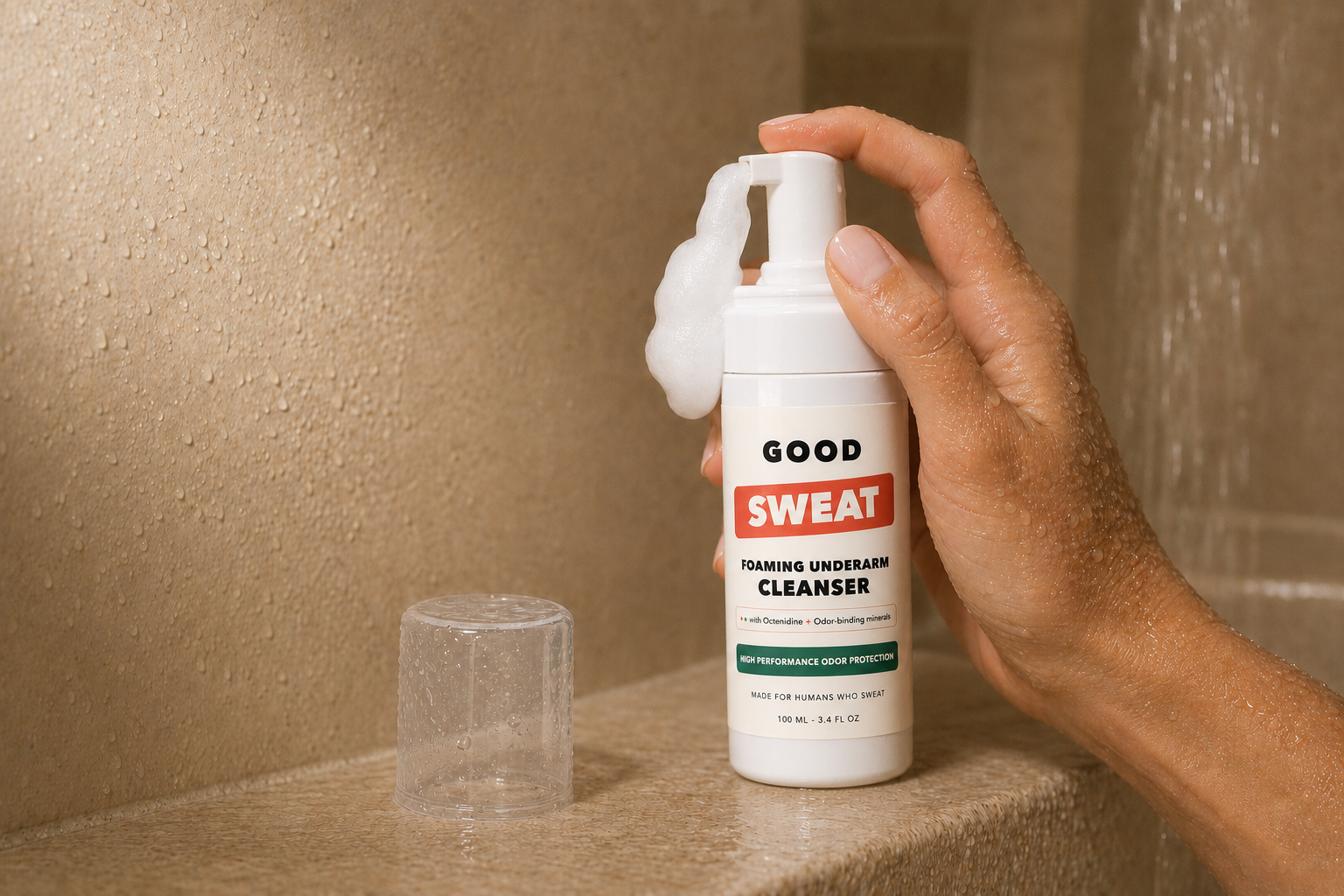 GoodSweat cleanser bottle dispensing foam in a shower.