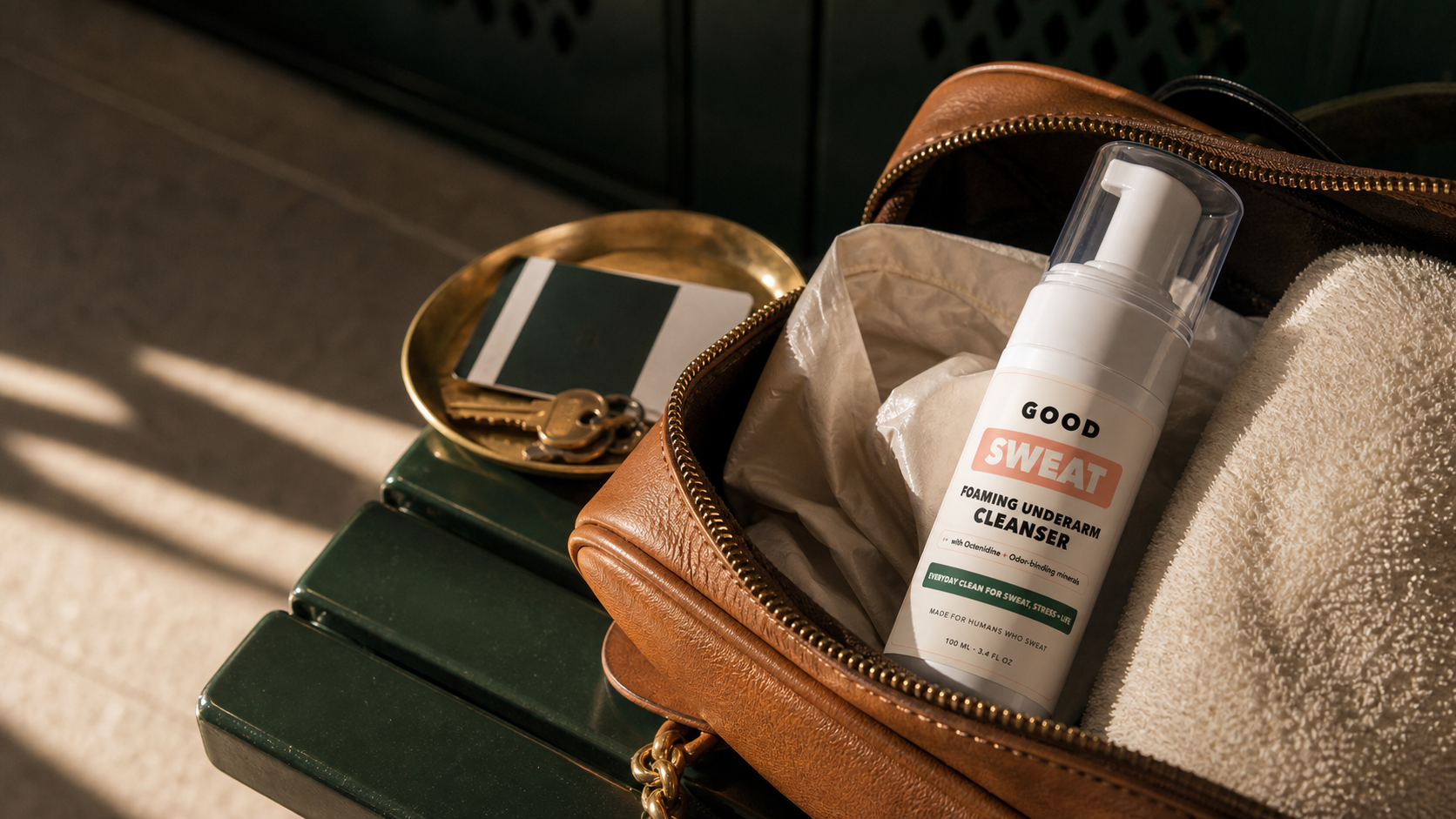 GoodSweat bottle packed in a leather dopp kit with a towel and travel items.