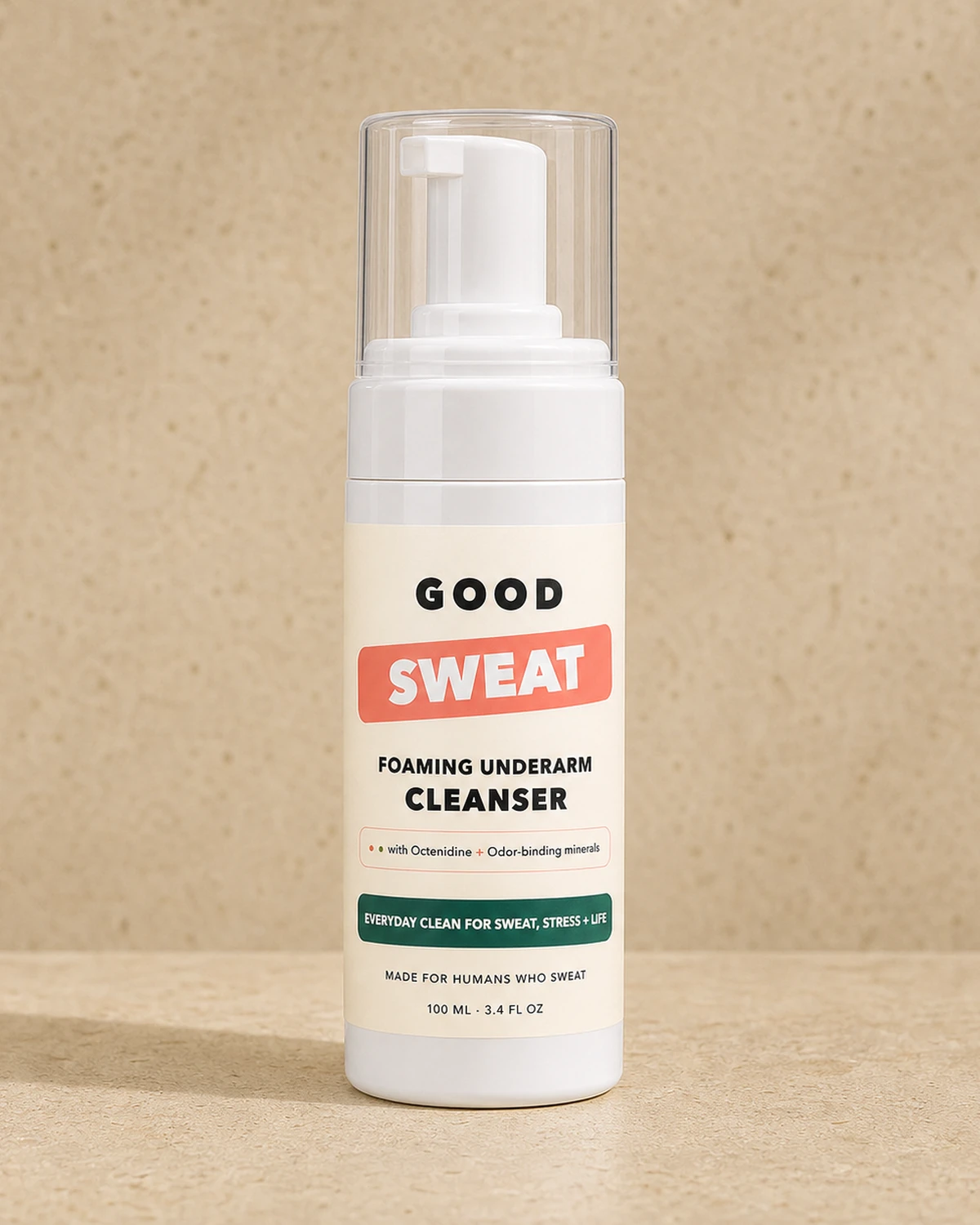 GoodSweat foaming underarm cleanser bottle photographed on warm stone.